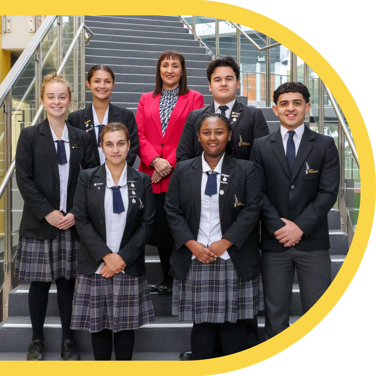 Students standing on the stairs with the principal of St Agnes Catholic High School Rooty Hill